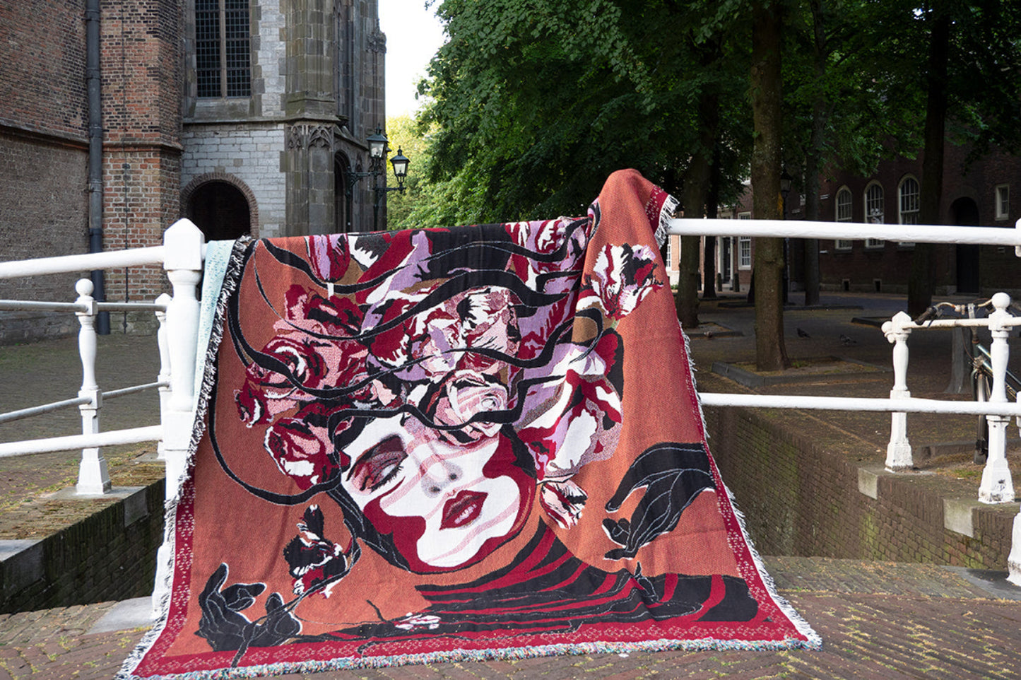 Luxe Jaquard deken met gebloemde portrait gedrapeerd op een brug