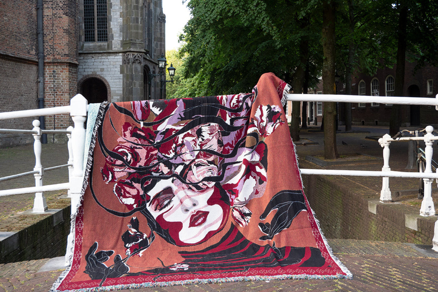 Luxe Jaquard deken met gebloemde portrait gedrapeerd op een brug